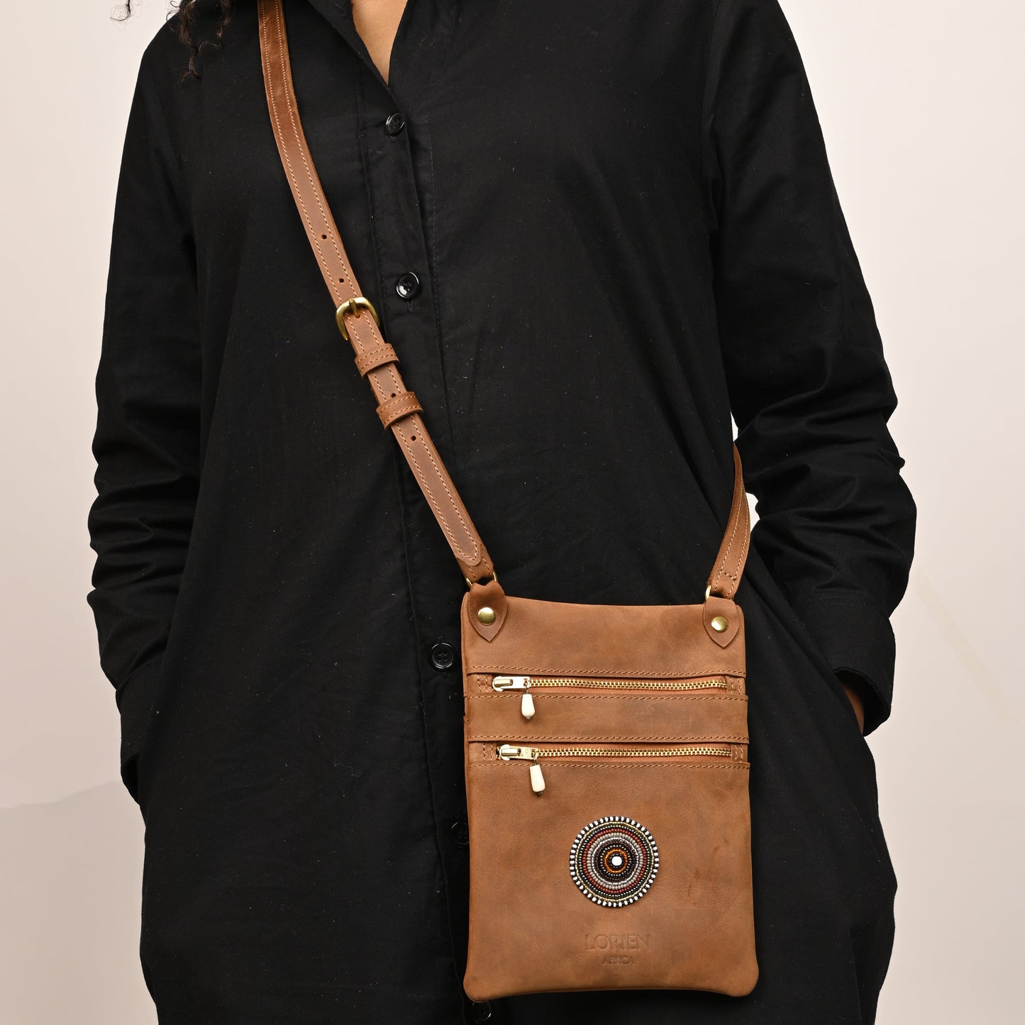 Brown leather pouch with decorative beads attached.